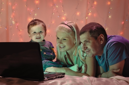 woman child and man on background from garland with laptopの写真素材