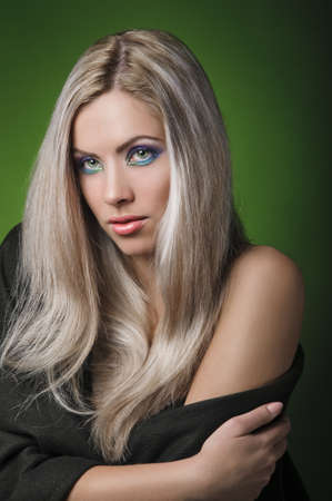 portrait of beautiful peroxide blonde girl on green backgroundの写真素材