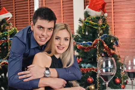 portrait of young couple about new year tree with glasses of wineの写真素材