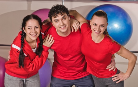 portrait of three young sport people with fitness ball back