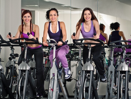 three spinning women in the fitness clubの写真素材