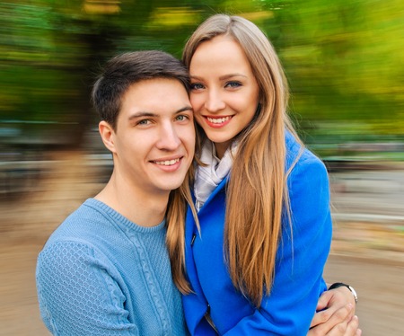 couple having fun on spinning roundabout. Autumn. Naturally blur motionの写真素材