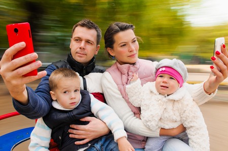 Family having fun on spinning roundabout. selfie Portrait. Naturally blur motionの写真素材