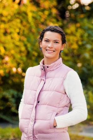 Autumn woman portrait smiling outdoors at the parkの写真素材