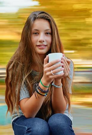 Attractive girl with a cup. background with natural motion blurの写真素材