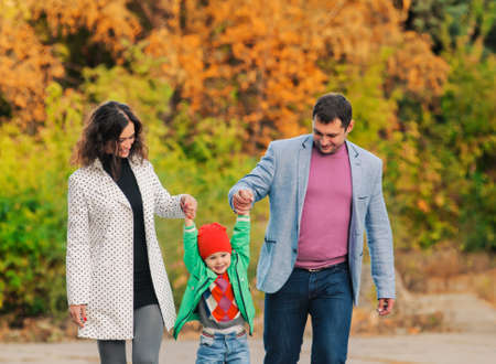 Young family walking in the park. Autumn.
