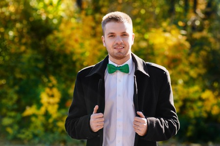 Handsome man in the park. Autumn sceneryの写真素材