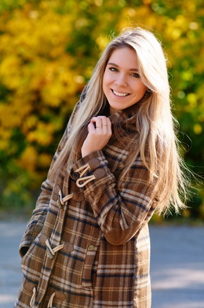 Autumn woman portrait smiling outdoors at the parkの写真素材