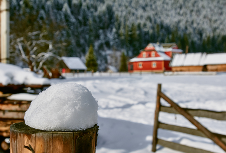 Old farm in the mountains at winter. focus on foreground snow of the fence.  Ukraine Carpathiansの写真素材