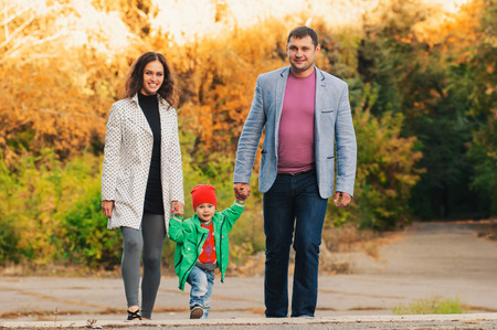 Young family walking in the park. Autumn.の写真素材