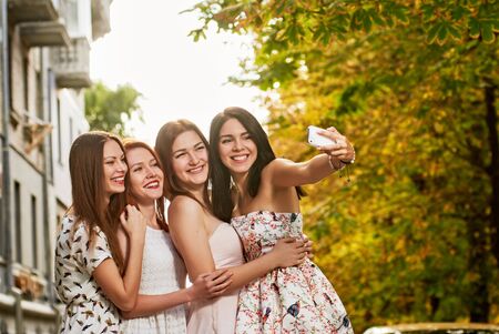 four beautiful friends having fun outdoor in autumn on the street. Outdoors, lifestyle.の写真素材