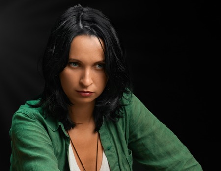 Attractive confident brunette woman portrait on dark backgroundの写真素材