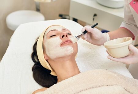 young beautiful woman with facial mask, spa treatment