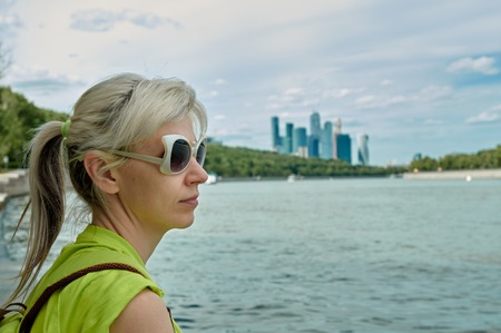 woman sitting in city park near Moscow river background is business Centre moscow-cityの写真素材