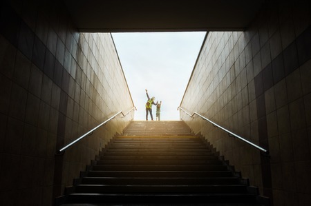 mother and son walks up stairs to toward the light at the top. Concept of success stairs.の写真素材