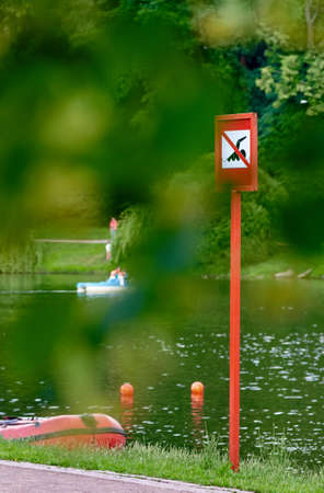 A no swimming danger sign at the beach. photo through the foliageの写真素材