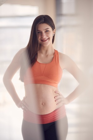 portrait of pretty sport pregnant woman indoors portraitの写真素材
