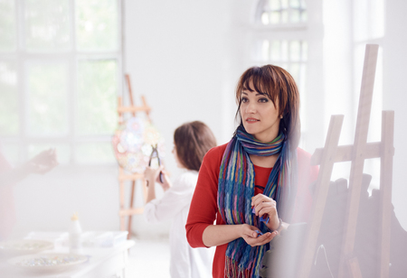 woman artist on workshop colorful glass mosaic indoor with little girl on backgroundの写真素材