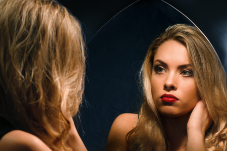 beautiful girl in lingerie looking at herself in the mirrorの写真素材