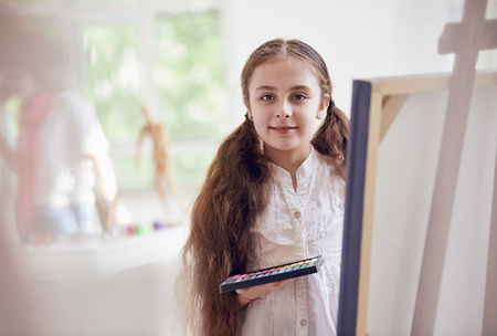 Long-haired girl artist about canvas with pastelの写真素材