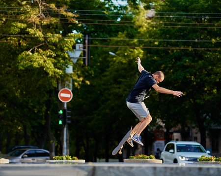 Young skater doing tricks with skateboard in city park. Ukraine, Dnepr- July 08, 2017のeditorial素材