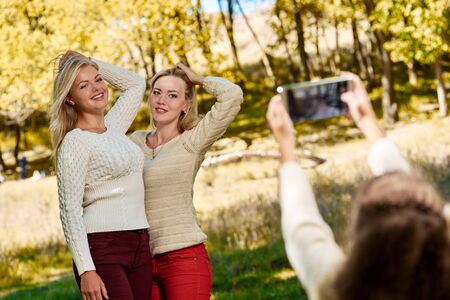 Girl photographing her sistersの写真素材