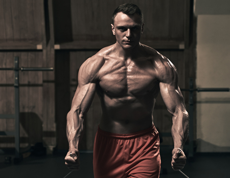 Athletic muscular man working out in gym and doing exercises for chest, the image was desaturated ang tonedの写真素材