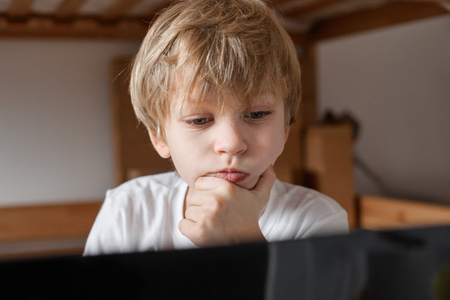 pensive boy with laptopの写真素材