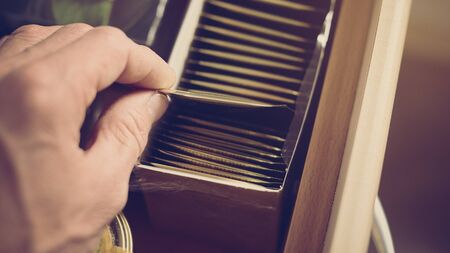 Closeup of male hand taking out tea bag of the package, image with warm vintage toningの写真素材