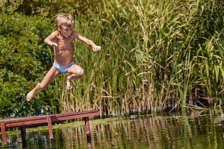 cute Boy jumping into the riverの写真素材