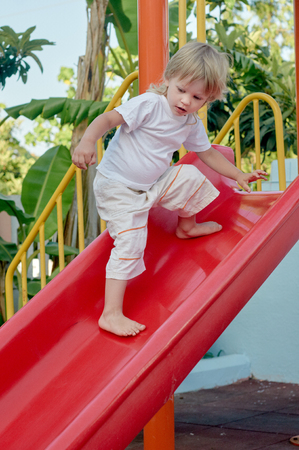 Boy on playground slideの写真素材