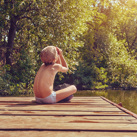 Resting boy near riverの写真素材