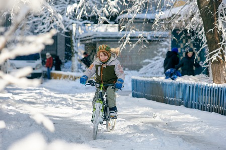 a boy riding a bicycle during a winterの写真素材
