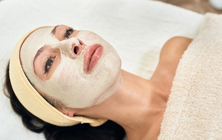 Portrait of attractive young woman lying in beauty salon with mask on her faceの写真素材