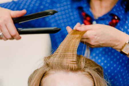 Dnepr, Ukraine- September 11, 2018: stylist working with curling iron. Open workshop master class of hairdressing Maya Norkinaのeditorial素材