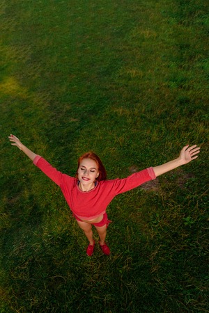 Top view photo of happy healthy sportswoman on the background of green grassの写真素材