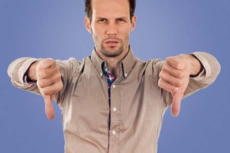 man giving thumbs down gesture. negative sign. on blue color backgroundの写真素材
