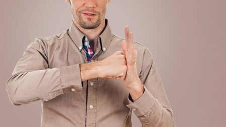 man cheering, raising his clenched fist arm. isolated on background tortilla shade brown colorの写真素材