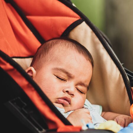 Closeup portrait of little cute boy sleeping in pramの写真素材