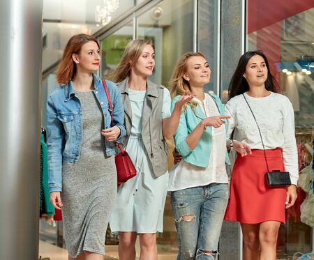 Group of happy smiling women walking in shopping mallの写真素材