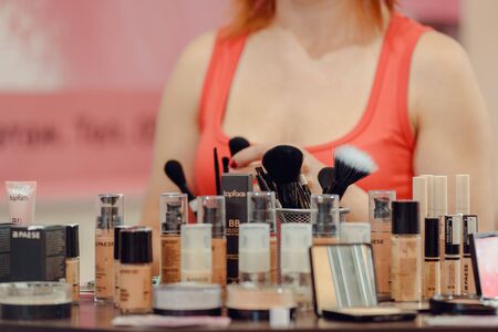 Dnepr, Ukraine- Maj 18, 2019: Female beauty consultant demonstrating makeup brushes and cosmetics productsのeditorial素材
