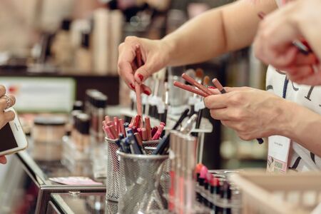 Dnepr, Ukraine- Maj 18, 2019: Closeup of female client choosing color of lips pencilのeditorial素材