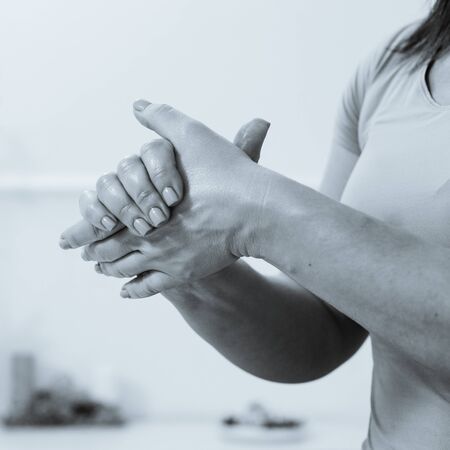 Closeup of professional strong female masseur stretching hands before procedure