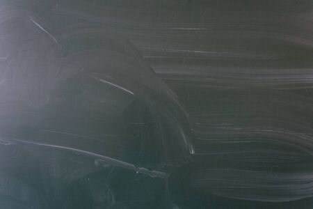 Closeup of blank dirty school blackboard with traces of chalk