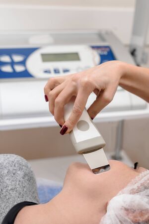 Woman receiving ultrasound rejuvenation procedure in modern beauty salonの写真素材