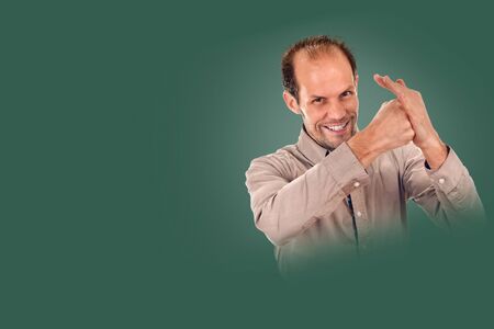 young man showing negative sign on background pine shade green