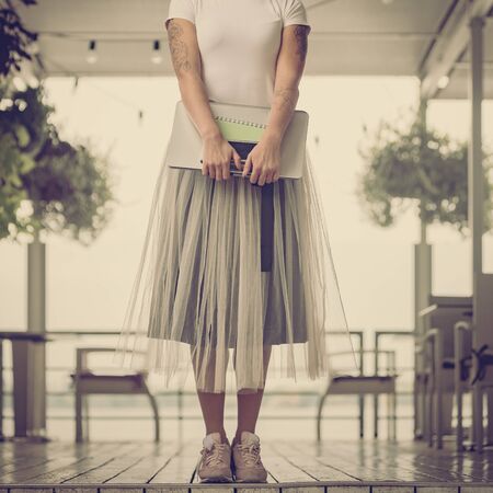 young woman freelancer holding laptop, smartphone and notebookの写真素材