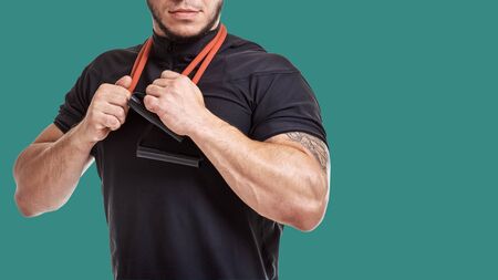 muscular man exercising with elastic expander on green background