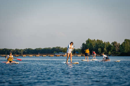 Dnepr, Ukraine- July 17, 2019: Active people doing yoga on sup boardsのeditorial素材