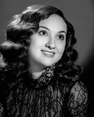 Closeup portrait of smiling elegant beautiful woman with curly hair. image in black and white...